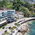 Hotel New York in Vlorë beachfront hotel beside the sea and rocky shore, with hillside backdrop