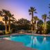 Best Western Plus Valdosta Hotel & Suites pool at dusk with palm trees and lounge chairs in Valdosta