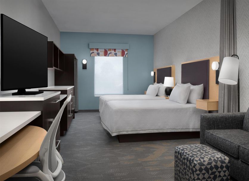 Home2 Suites by Hilton Lake City guest room with two beds, TV, sofa and window wall