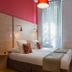 Hôtel Edmond Rostand Marseille guest room with twin beds, red accent wall and tall window