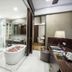 R Hotel Rancamaya Bogor bathroom with freestanding tub, glass shower, and vanity