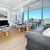 Pumicestone Blue in Caloundra living room with ocean-view balcony, swivel chairs, TV and sofa