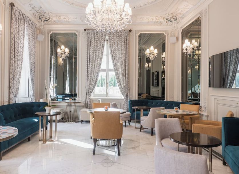 Villa Genesis in Menton lounge with chandelier, mirrored walls, velvet seating and bright windows