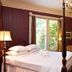 Beaufort House Inn Asheville room with four-poster bed, chandelier, and garden-view windows