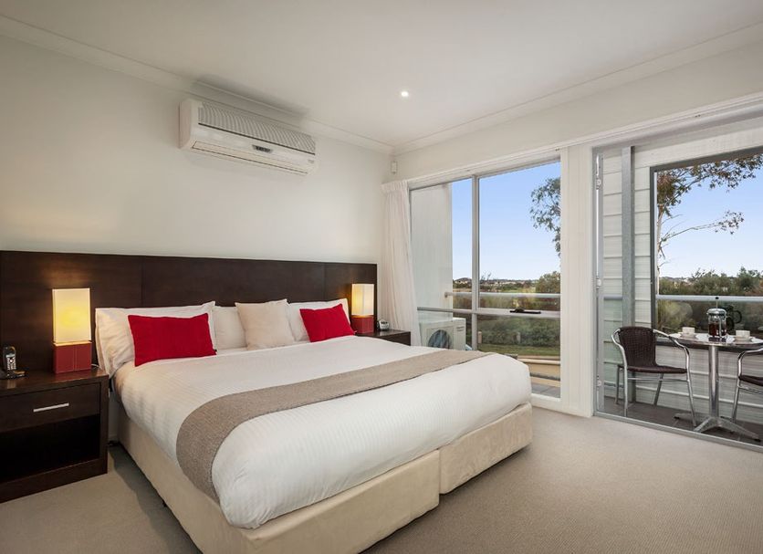 Quest Sanctuary Lakes in Melbourne bedroom with balcony and lake view through open doors