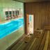 Indoor pool and sauna at The Landmark Hotel in Baku with glass wall views of lounge chairs