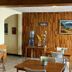Hostal Los Volcanes Guatemala City lobby seating area with wood-paneled wall and table displays