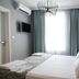 Luna Boutique Hotel Antalya guest room with king bed, brick accent wall, wall-mounted TV and sheer curtains