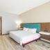 Hampton Inn Dade City - Zephyrhills guest room with king bed, TV, desk and hallway view