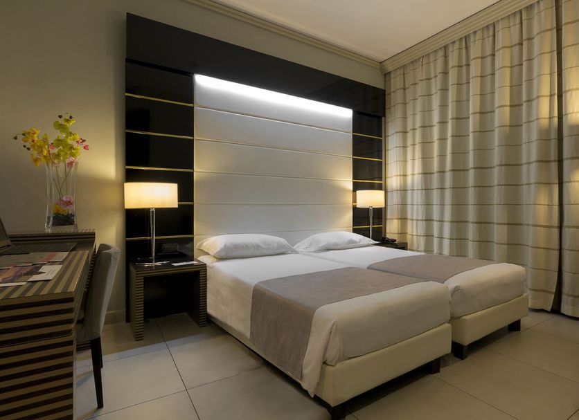 Palazzo Salgar Naples guest room with twin beds, modern lighting and floor-to-ceiling curtains