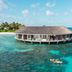 Kagi Maldives Resort & Spa overwater villa in Kagi with turquoise ocean and snorkeler nearby