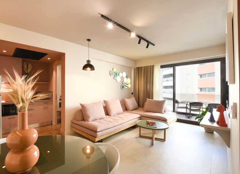 Pavo Art Hotel in Heraklion suite with sofa, coffee table, balcony door and city view