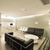 60 West Hotel Hong Kong lounge with black sofas, white chairs, and a small bar counter