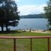 White Oak Motel & Cottages in Holderness: lakeside beach and grassy lawn with mountain views