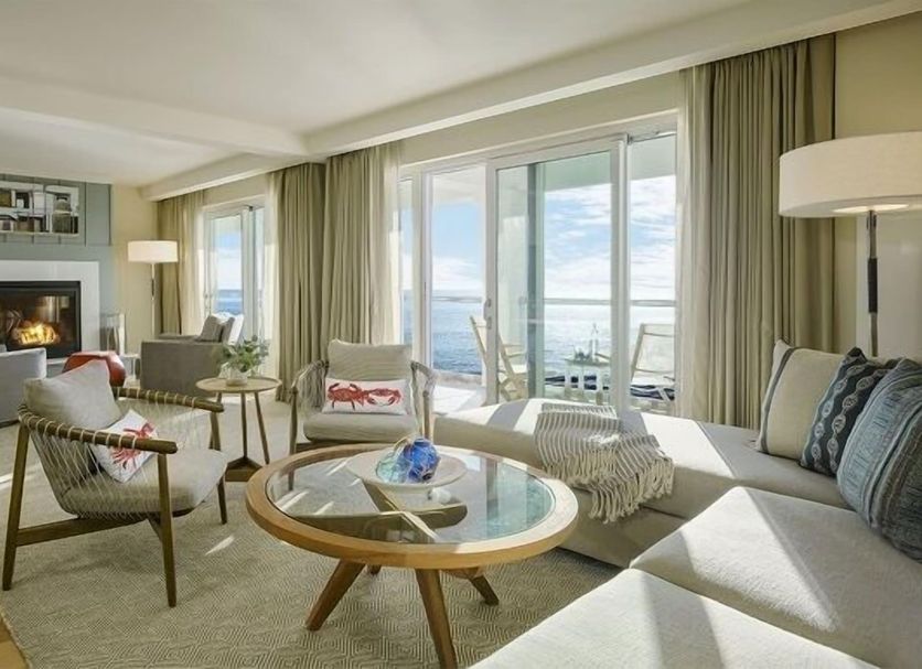 Cliff House Maine in Cape Neddick: ocean-view suite with fireplace, seating area, and balcony doors