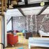 Homeplanet Hostel Leipzig common room with colorful chairs, brick wall, and wooden staircase