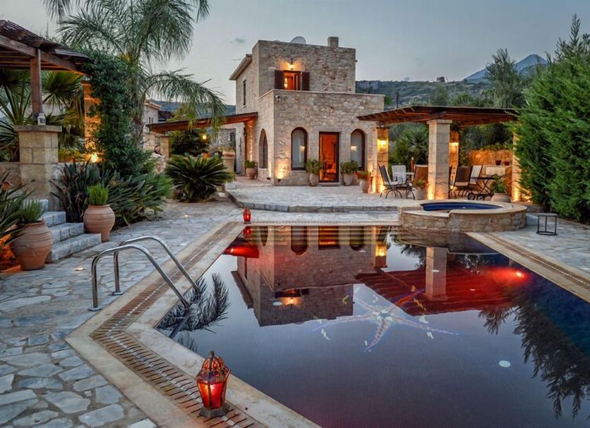 Olympia Villas in Stoupa, stone villa with lit pool, palm trees and mountain views