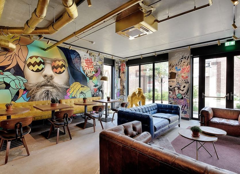 Hotel the Match in Eindhoven lounge with colorful mural wall, leather seating, and large windows