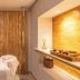 Rio Quente Cristal Resorts treatment room with massage bed and warm wood accent wall