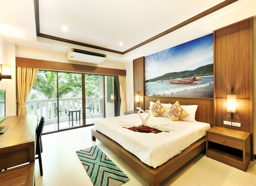 Ratana Hill Patong in Patong: bedroom with king bed, balcony doors, desk and wall art