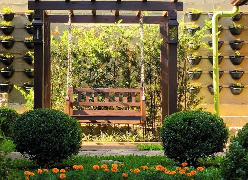 Pousada Charm Canela in Canela, garden patio with bench, hanging planters, and trimmed shrubs