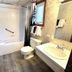 White Mountain Motel And Cottages Lincoln bathroom with tub-shower, toilet, sink and wood-look floor