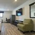 Home Suites Thief River Falls room with bed, desk, TV, chair and armchair