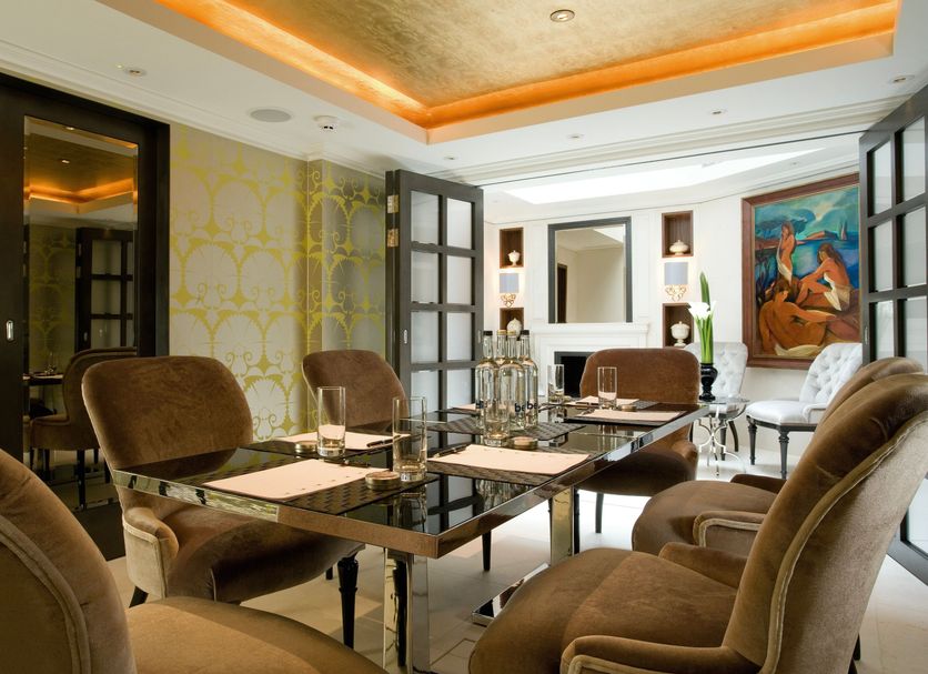 Althoff St James's Hotel & Club London meeting room with glass table, brown chairs and warm ceiling lighting in London