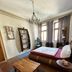 Homeplanet Hostel Leipzig room with bed, chandelier, wooden table and tall windows