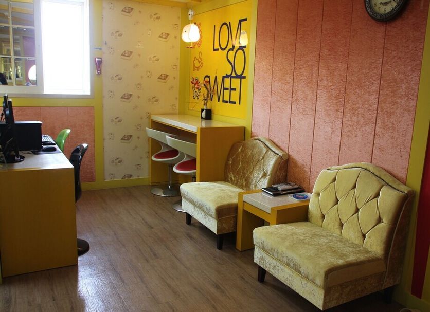 Time Motel in Gyeongju guest room with desk, chairs, and bright decorative wall art