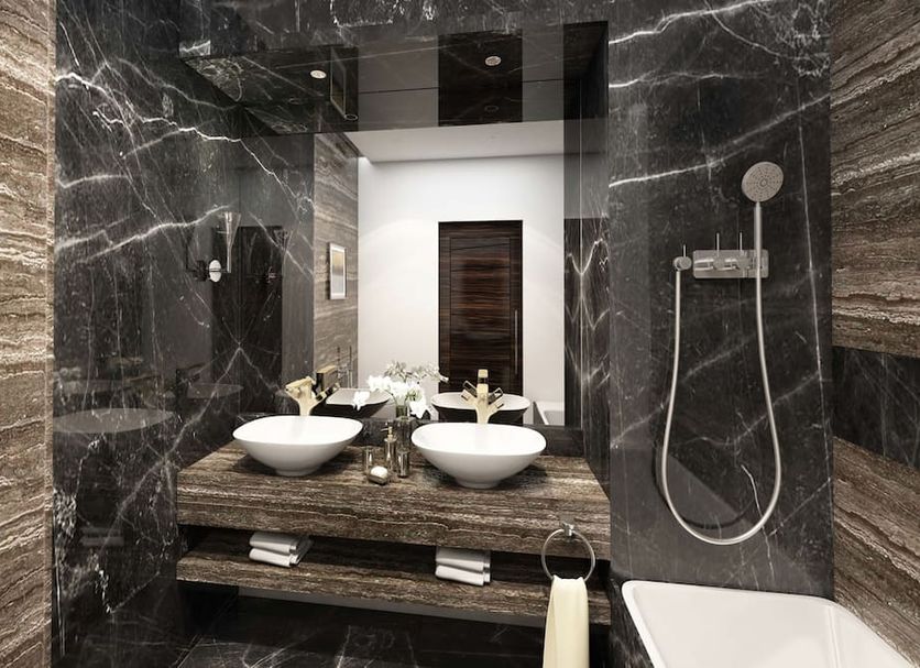 Khalidia Palace Hotel Dubai bathroom with double vessel sinks, marble walls and a handheld shower