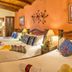 Hotel Casa del Parque in Antigua room with three beds, wood-beamed ceiling and warm orange walls