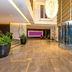 Flora Park Deluxe Hotel Apartments lobby in Dubai with marble floors, potted plants and a glass revolving door