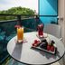 Olimpia Hotel & Aparthotel balcony with table, drinks, fruit tray and glass railing in San Michele al Tagliamento