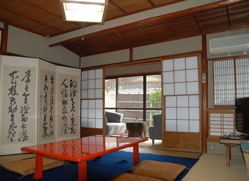 Yadoya Manjiro in Kyoto: traditional tatami room with low red table, shoji screens, and balcony seating