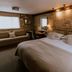 Widbrook Grange in Bradford-on-Avon bedroom with stone walls, king bed, desk and seating area