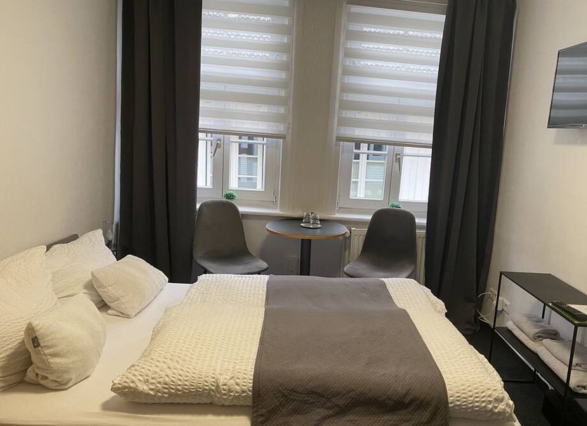 Altstadt-Hotel Gosequell room in Goslar with double bed, seating nook by window, and wall-mounted TV