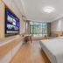 Tizi Hostel in Shanghai guest room with queen bed, wall-mounted TV, desk, and large window