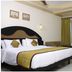 Hotel Sea View in Kanyakumari bedroom with king bed, sofa, table, and large window with curtains