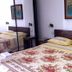 Agave Alghero guest room in Alghero with double bed, floral bedspread, and wall art