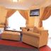 Rainbow Ruiru Resort Nairobi lounge with sofas, ottoman, TV, and bright window seating