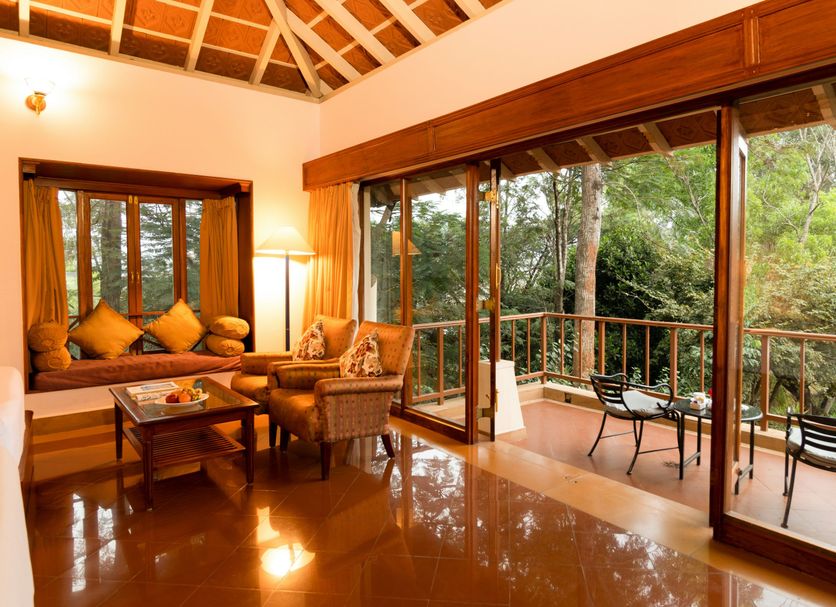 Gateway Chikmagalur in Chikamagalur: airy lounge with forest-view balcony and sliding glass doors