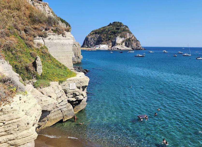 Villa Bina Sea Hotel in Serrara Fontana with cliffside coast, clear blue sea, and boats offshore