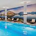 Hilton Munich Airport indoor pool with mountain mural and lounge chairs in Munich