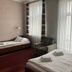 Aneks Kazimierz in Krakow guest room with two single beds, plaid armchair and tall windows