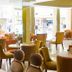 Royal Garden Hotel, Ozamiz lounge with mustard chairs and tables in a bright lobby seating area