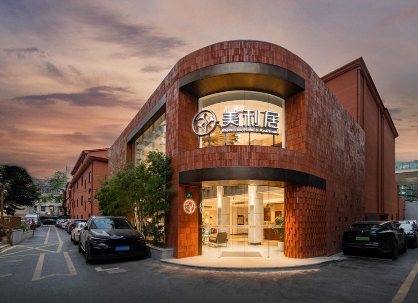 24k International Hotel People's Square in Shanghai at dusk, showing the curved brick exterior and glowing entrance