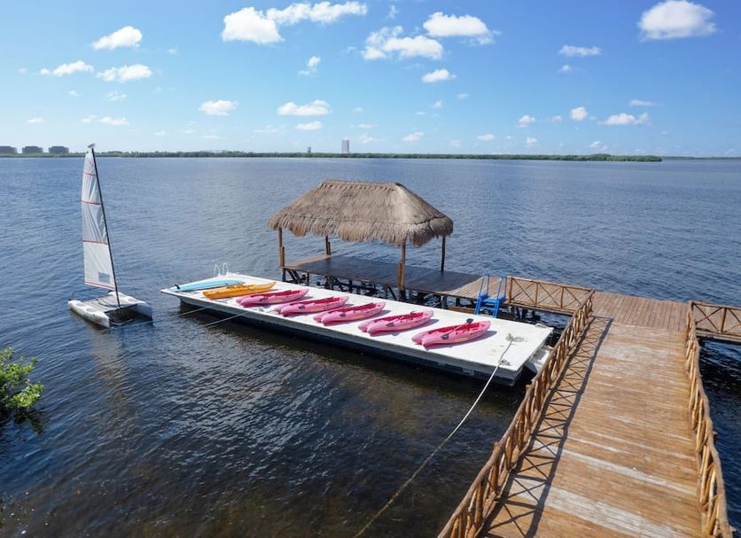 Gr Solaris Caribe - All Inclusive in Cancún with a docked floating kayak and thatched palapa over calm water