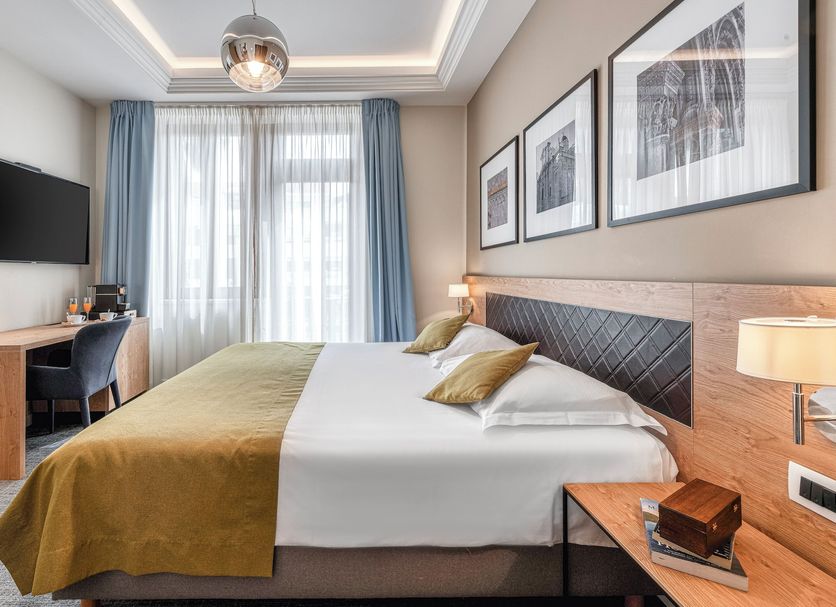 Boutique Villa Filaus in Dubrovnik guest room with double bed, desk, wall-mounted TV and sheer curtains