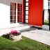 Oporto Hotel Boutique in Santiago with a red-accented entrance and flower pot beside a small lawn.
